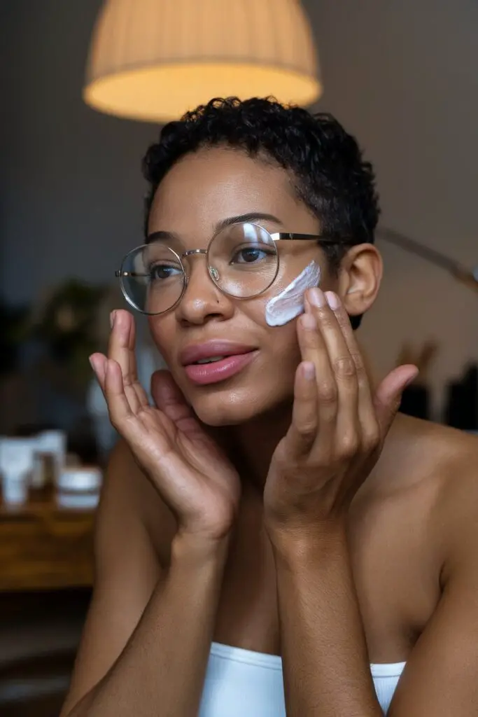 Mujer aplicando crema hidratante en su rostro