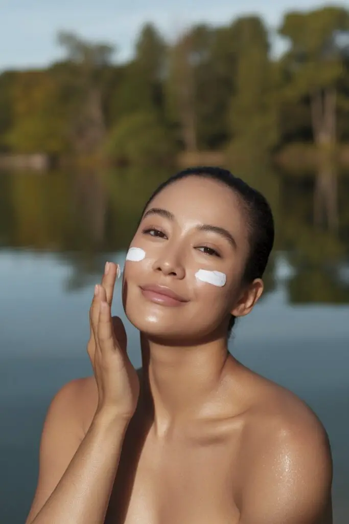 Mujer aplicando protector solar en su rostro